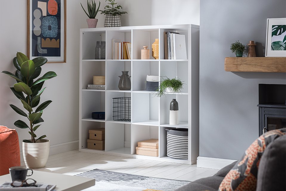 A large 16 cubed white torage in a living room.